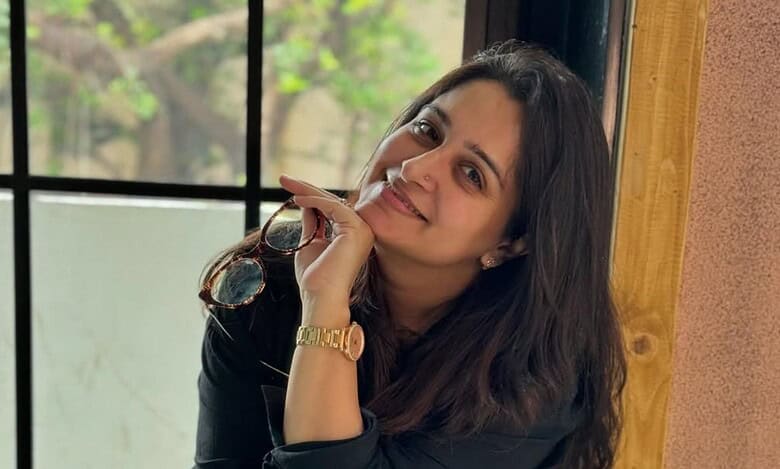 Dipika Kakar sitting next to a window, holding her eye glasses
