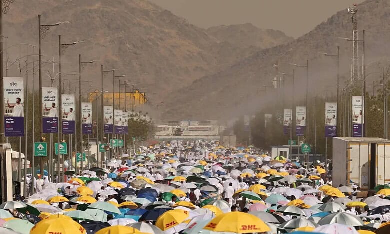Pilgrims walk under colourful umbrellas during Haj 2024 in Saudi Arabia, braving the summer heat on their spiritual journey.