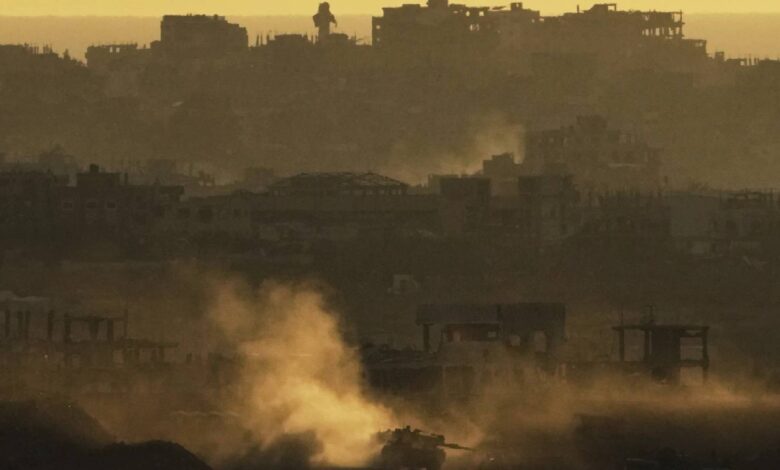 "An Israeli army tank kicks up dust as it manoeuvres in the Gaza Strip, seen from southern Israel at sunset on May 4.