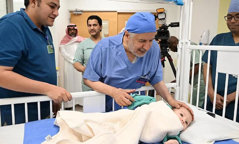 Mohammed Abdulrahman Juma, a Egyptian boy with a parasitic twin, lies in a hospital bed surrounded by a medical team in Saudi Arabia following a successful surgery.