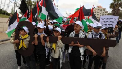 Children hold flags and signs during a protest in jerusalem