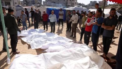 People gather around bodies of Palestinians wrapped in white shrouds after an Israeli airstrike in Gaza.