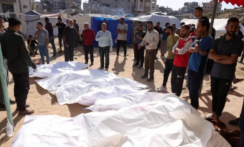 People gather around bodies of Palestinians wrapped in white shrouds after an Israeli airstrike in Gaza.