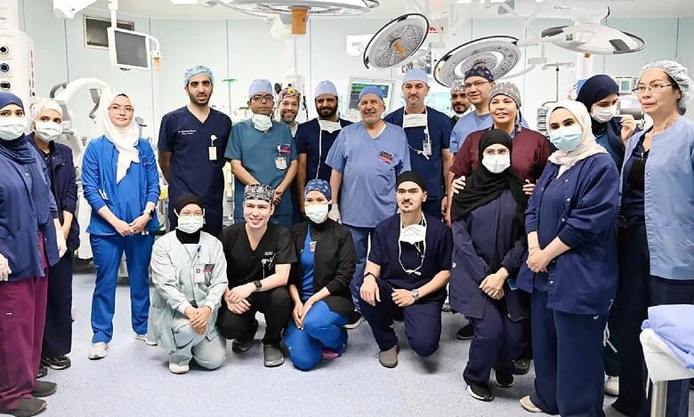 Saudi medical and surgical team poses in the operating theatre after completing a successful procedure.