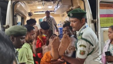 Woman carried out of ambulance by police and others after being injured in Goa temple stampede
