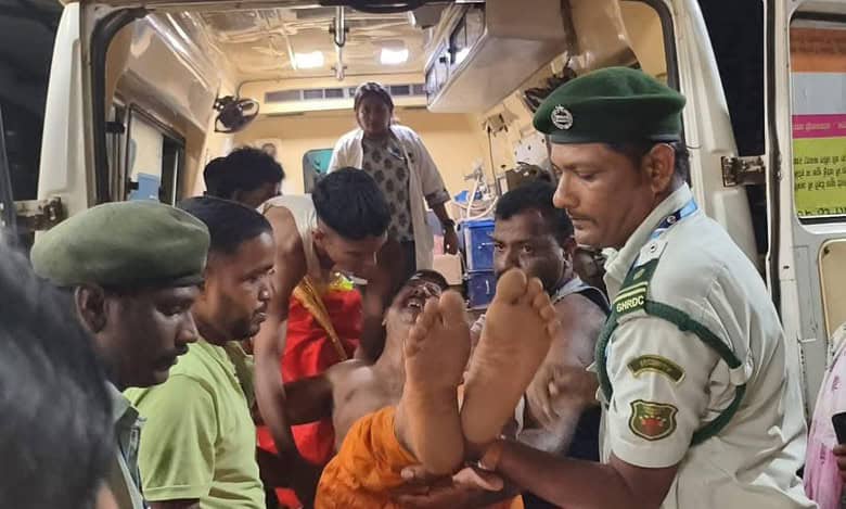 Woman carried out of ambulance by police and others after being injured in Goa temple stampede