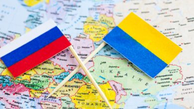 An image featuring the flags of Russia and Ukraine with a world map in the background