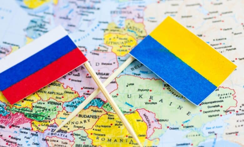An image featuring the flags of Russia and Ukraine with a world map in the background