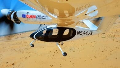 The image of a Joby Aviation’s electric aerial taxi with Dubai government branding seen mid-flight over a desert landscape during its first successful test.