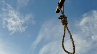 The image of a noose hanging from a wooden beam against a blue sky, symbolising execution.