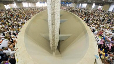 A large crowd of Haj pilgrims gathers around the Jamarat pillars in a spacious indoor area, performing the ritual of stoning the devil on June 6, 2025.