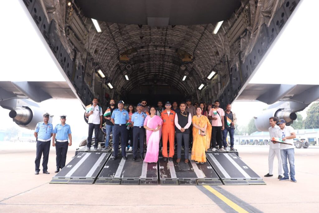Indian evacuees and IAF personnel pose with officials inside IAF C-17 aircraft after arrival from Israel under Operation Sindhu.