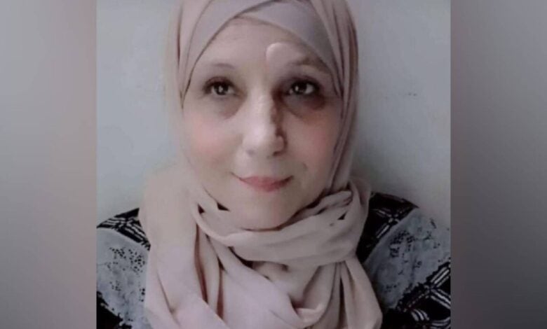 The image of of a 66-year-old Palestinian woman wearing a light-coloured hijab and patterned top, looking slightly upward with a calm expression.