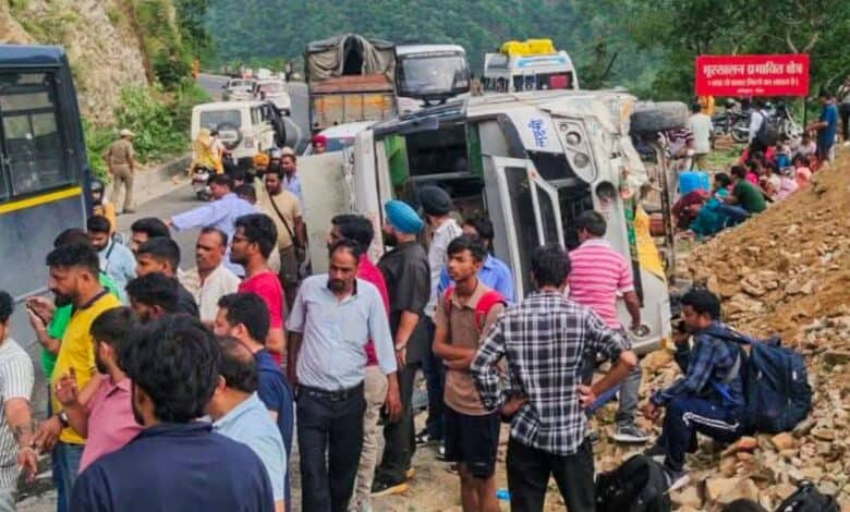 People wait at a roadside after a landslide occurred in Uttarakhan