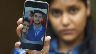 Pushpa Joshi, sister of Bipin Joshi, a Nepali man taken hostage by Hamas on Oct. 7, 2023, shows photos of them together during an interview with The Associated Press in Kathmandu, Nepal, Thursday, June 12, 2025. (AP Photo/Niranjan Shrestha)