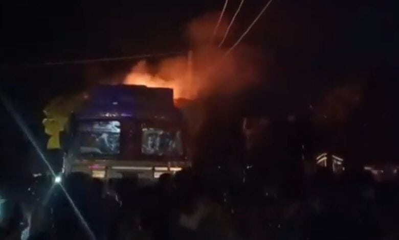 The image displays a picture of a Hindutva mob setting a truck in fire in UP
