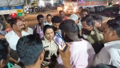 The image displays a picture of a female police officer talking to some men in Telangana