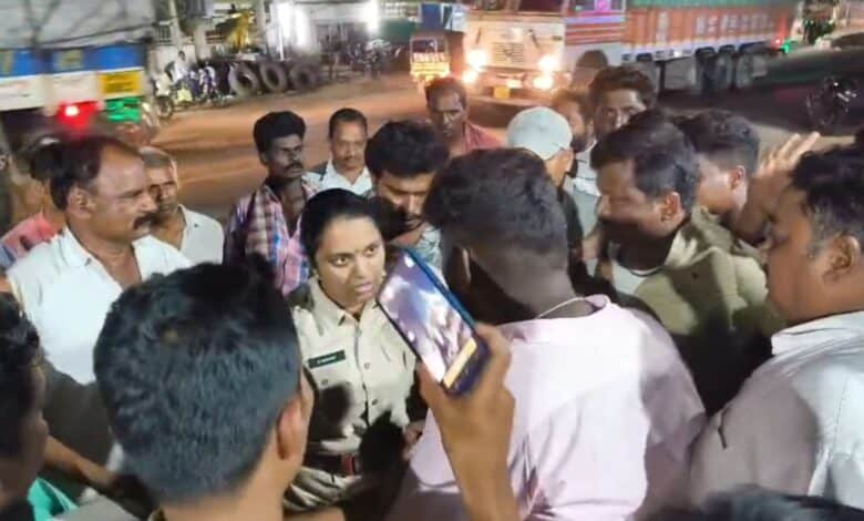 The image displays a picture of a female police officer talking to some men in Telangana