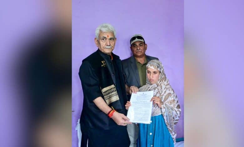 The image displays a picture of J-K Lieutenant Governor Manoj Sinha handing over the appointment letter to Adil Shah’s wife, Gulnaz Akhter