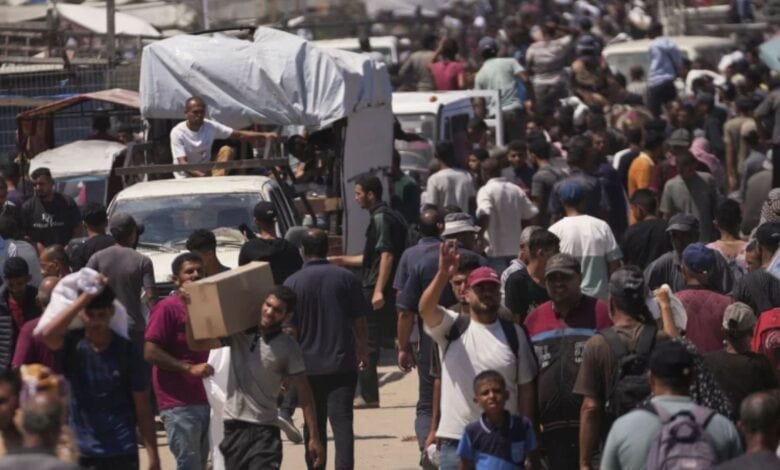 Palestinians carry bags containing food and humanitarian aid packages delivered by the Gaza Humanitarian Foundation in southern Gaza Strip on Sunday