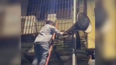 Mumbai police officer removing a loudspeaker in a mosque in the city