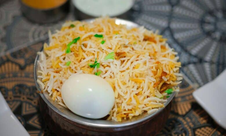 The image displays a picture of biryani with an egg