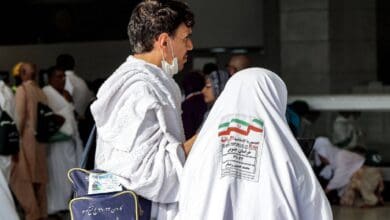 The image of a Iranian Haj pilgrims ihram attire at a gathering point, with identification tags visible on their clothing during Haj 2025 in Saudi Arabia.