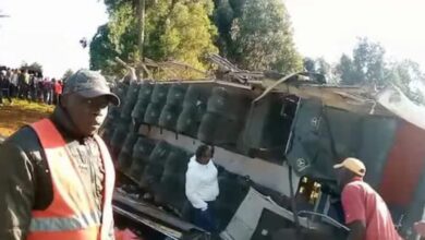 Crowd gathers around an overturned tour bus in Kenya after a fatal accident; emergency responders and bystanders are seen at the scene.
