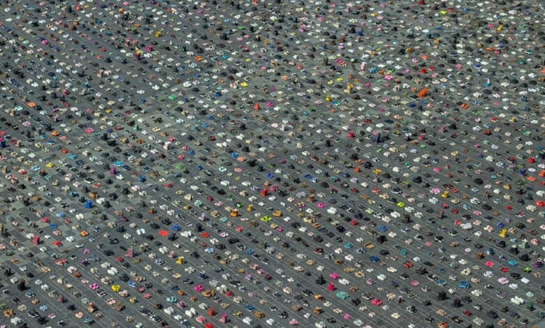 Aerial view of thousands of children's shoes arranged in neat rows across Stadhuisplein (City Hall Square) in Almere, Netherlands, as part of a memorial installation for Palestinian children killed in Gaza.