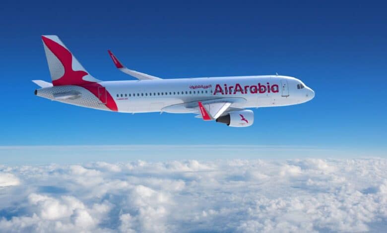 The image of Air Arabia Airbus A320 aircraft flying above the clouds with a clear blue sky in the background.