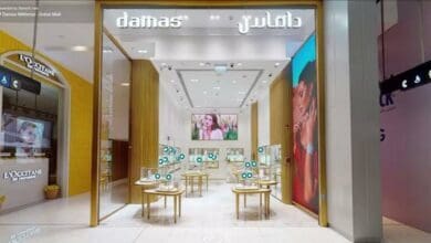 A modern Damas jewellery store in Dubai Mall, featuring sleek interiors, display tables with jewellery, and illuminated branding in English and Arabic.