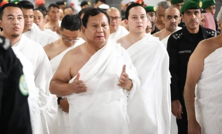A group of men dressed in white pilgrimage garments, with Indonesian President Prabowo Subianto as the central figure gesturing with both hands, performing the Umrah pilgrimage at the Grand Mosque in Makkah.