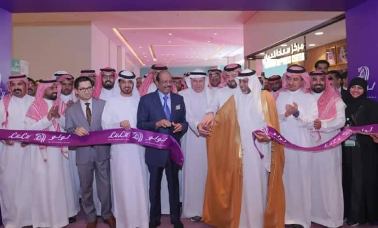 A group of people, including Yusuff ali in formal suits, are gathered for the grand inauguration of a new LuLu hypermarket.