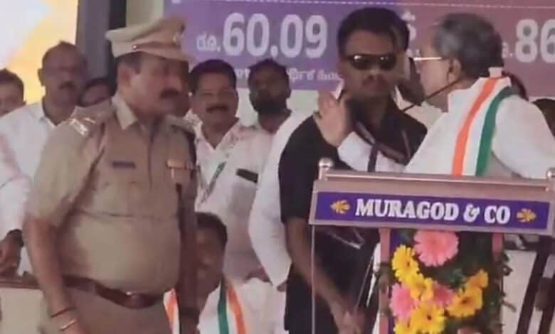 Karnataka CM Siddaramaiah raises his hand on ASP Narayan Baramani during a Congress event in Belgavi
