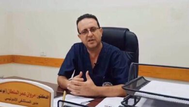 The image of Dr Marwan al-Sultan, former director of the Indonesian Hospital in Gaza, sits at his desk wearing navy blue medical scrubs.