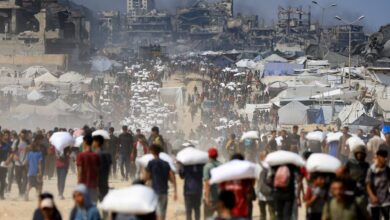 Palestinians carry aid packages through a crowded street in Beit Lahia, northern Gaza, on July 20, 2025, amid a worsening hunger crisis.