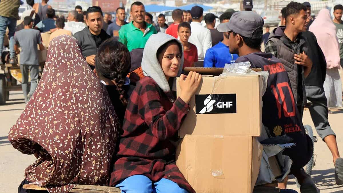 Displaced Palestinians receive aid boxes in Rafah, southern Gaza Strip.