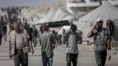 Palestinians carry aid supplies from a distribution point in northern Gaza.