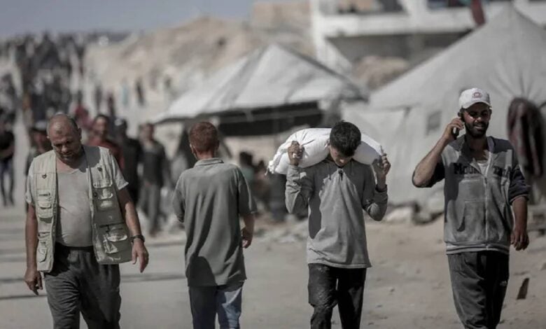 Palestinians carry aid supplies from a distribution point in northern Gaza.