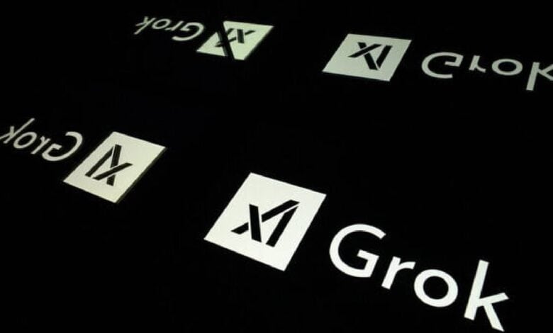 The logo of Elon Musk's AI chatbot Grok is seen reflected on a dark surface.