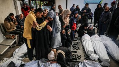 Palestinians mourning over the bodies of relatives, covered in white shrouds, killed in an overnight Israeli bombardment, at al-Najjar Hospital in Rafah.
