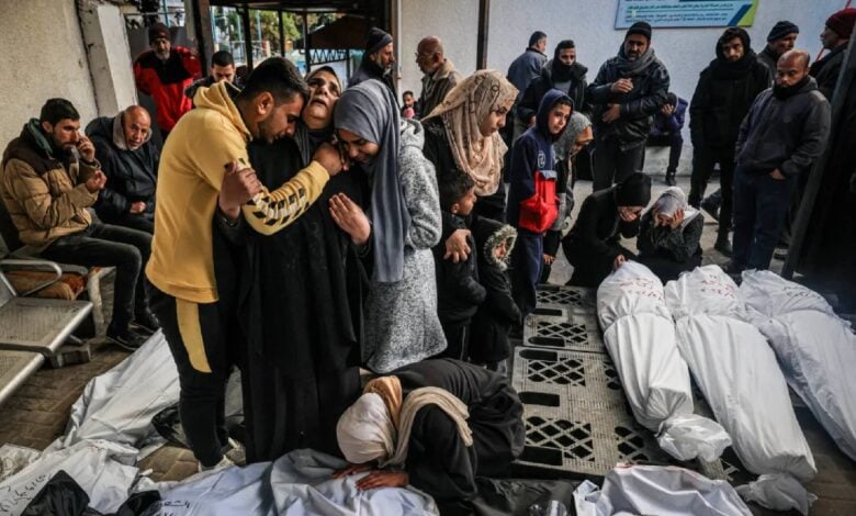 Palestinians mourning over the bodies of relatives, covered in white shrouds, killed in an overnight Israeli bombardment, at al-Najjar Hospital in Rafah.