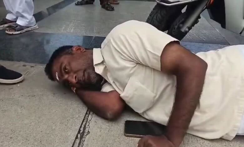 The image shows Raja Gangaram, a differently-abled person, lying on the floor and protesting after being humiliated when he tried to meet Jagtial distirct collector during Prajavani on Monday, August 11, 2025.