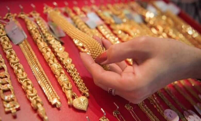 A shopper examines gold jewellery at a store display.