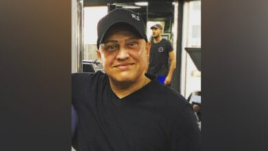 Indian businessman Abu Sabah wearing a black T-shirt and cap, smiling indoors.