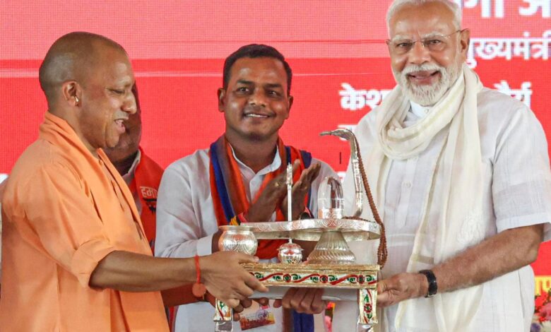 PM Modi being felicitated by UP CM Yogi Adityanath during a public meeting, in Varanasi.
