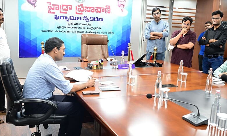 The image shows HYDRAA deputy commissioner N Ashok Kumar accepting petitions from complainants during Prajavani held at Buddha Bhavan in Secunderabad on Monday, August 11, 2025.