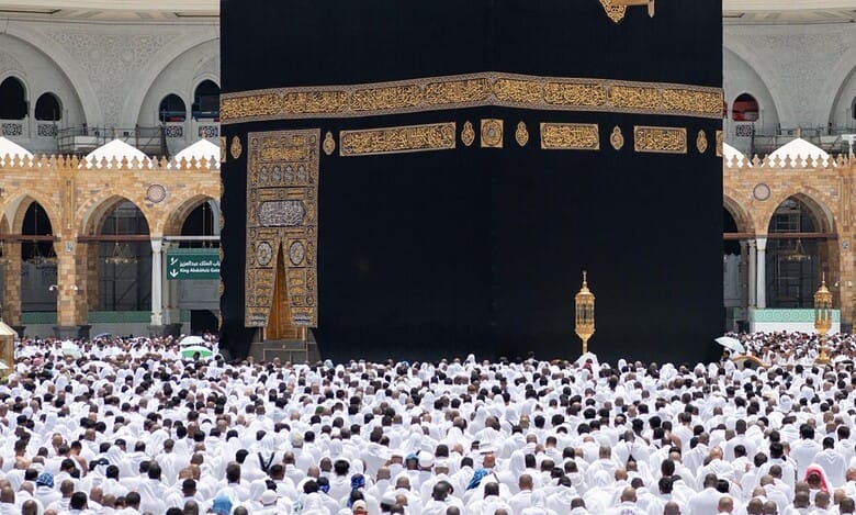 A large crowd of Umrah pilgrims dressed in white garments gathered around the Kaaba in Makkah.