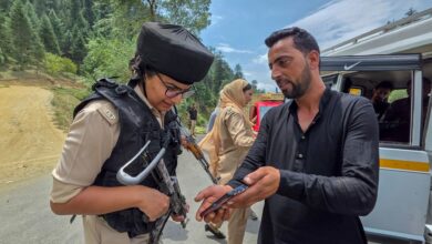 A J&K Police personnel checks documents of a commuter after security was beefed up ahead of Independence Day in Kupwara district (PTI Photo)
