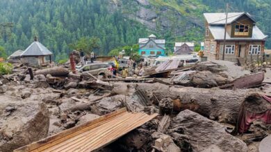 People move through the debris after a massive cloudburst at Chasoti village in Jammu and Kashmir's Kishtwar district on Thursday. (PTI Photo)